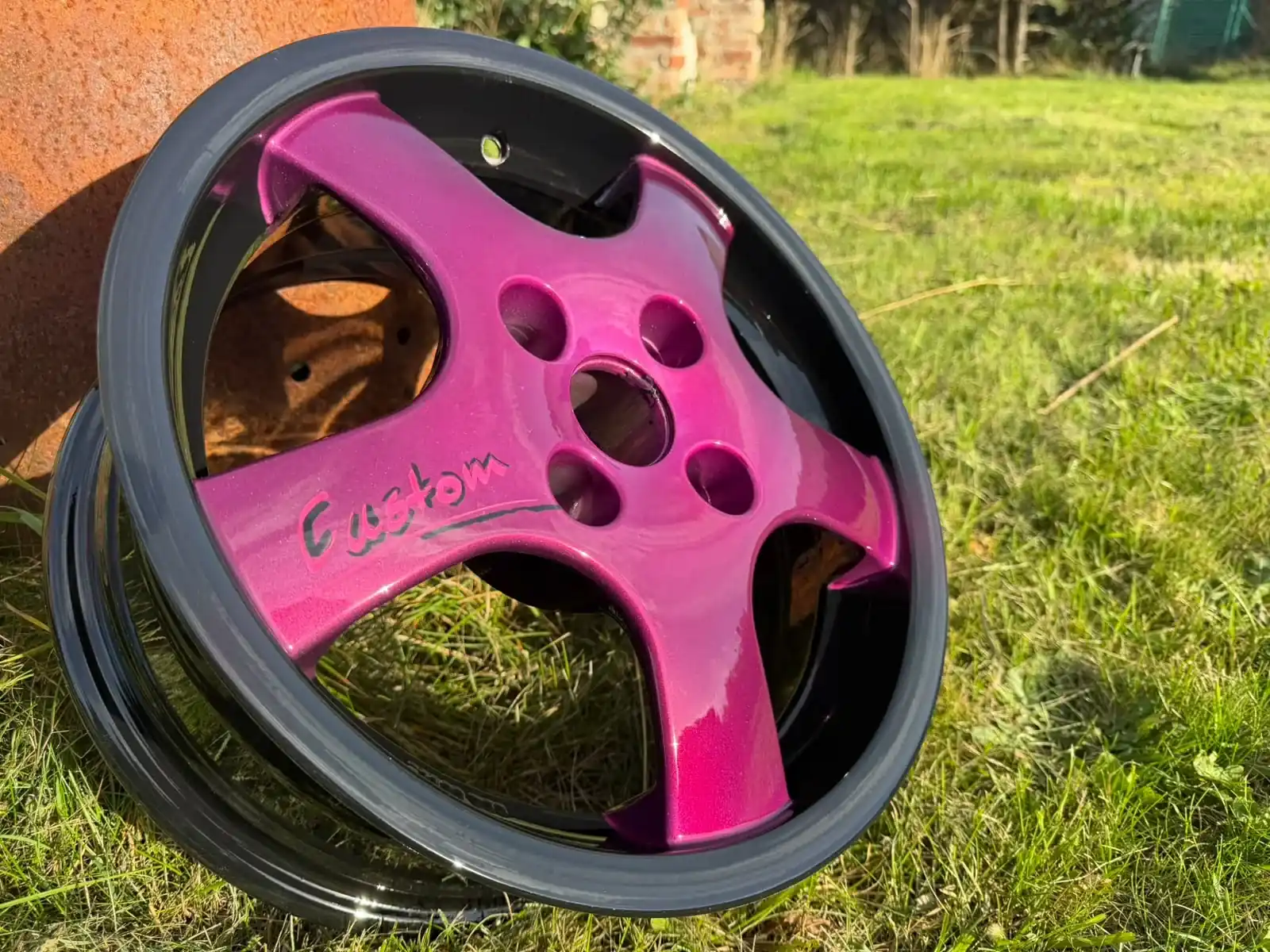Pink und schwarz beschichtete Felge in der Sonne